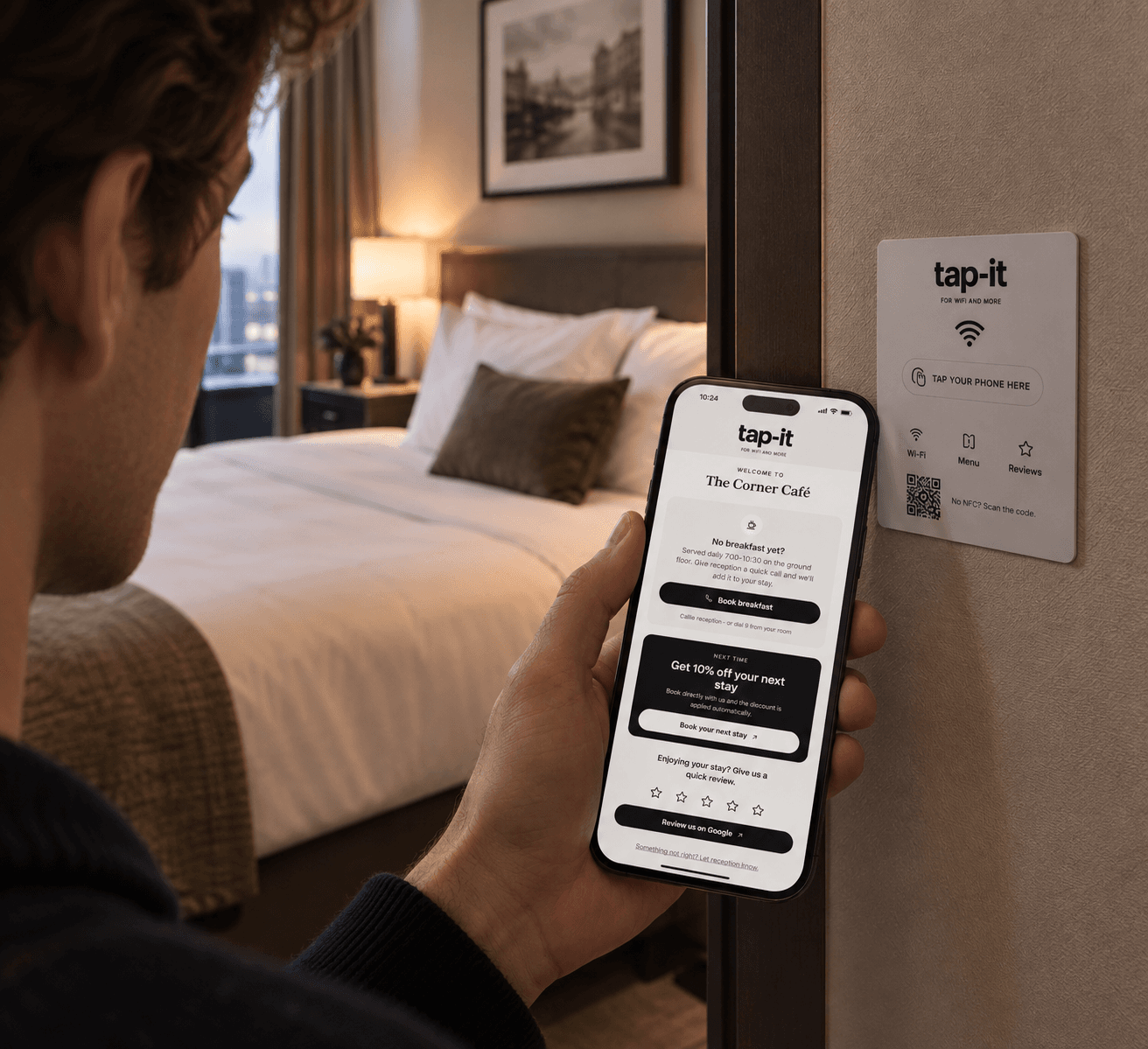 A hotel guest holds his phone with the tap-it guest page open, next to a white tap-it sign